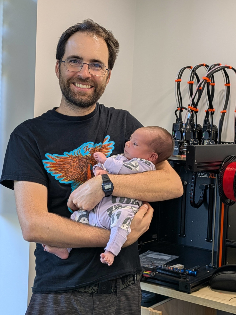 Jim holding baby in front of the Prusa